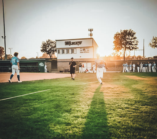 Young baseball player throwing a pitch at a showcase event, highlighting the risks and realities of youth baseball showcases